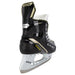 Black skates with gold accents, white laces and yellow lining