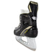 Black skates with gold accents, white laces and yellow lining