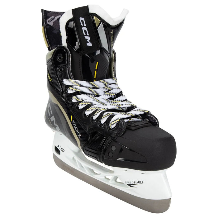 Black skates with gold accents, white laces and black lining
