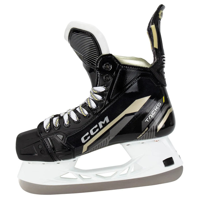 Black skates with gold accents, white laces and black lining